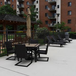 A serene outdoor area featuring lounge chairs and a table with an umbrella, perfect for relaxation by the pool.