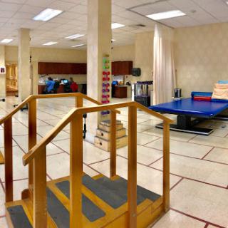 A spacious physical therapy room equipped with a ramp and therapy table for rehabilitation exercises.