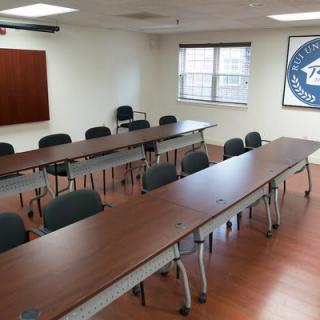An empty conference room with arranged tables and chairs.