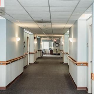 A well-lit corridor with handrails and light fixtures on the walls.