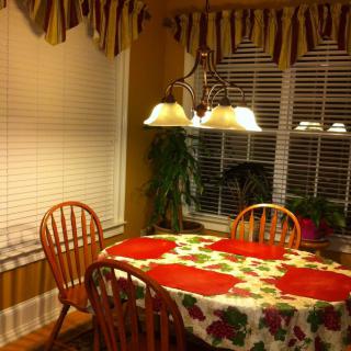 Cozy kitchen dining area with a floral tablecloth and warm lighting.