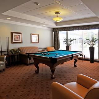 A cozy game room featuring a pool table surrounded by comfortable seating and decor.