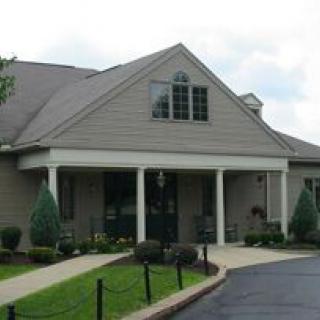 A residential-style building with a covered entrance and landscaped pathway.