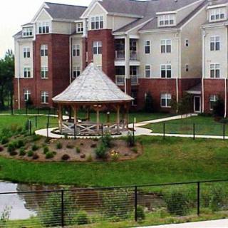 A modern apartment complex with a central gazebo and landscaped grounds.