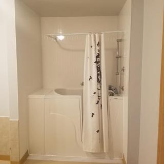 A bathroom with a bathtub and shower curtain.