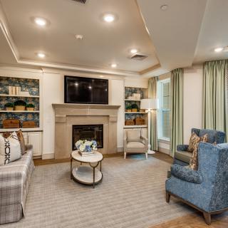 A cozy living room featuring a fireplace, comfortable seating, and built-in bookshelves.