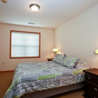 A cozy bedroom with a large bed, bedside tables, and lamps.