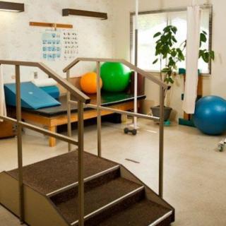 A physical therapy room equipped with exercise balls and a step platform.