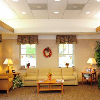 A cozy waiting room with comfortable sofas, warm lighting, and decorative elements.