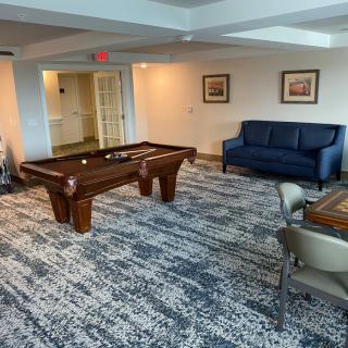 A cozy game room featuring a pool table and comfortable seating.