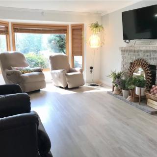 A cozy living room with recliners, a fireplace, and a large window letting in natural light.