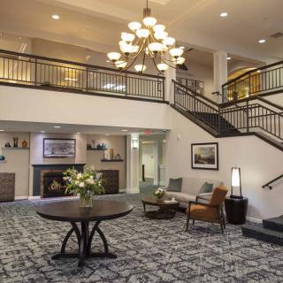 A spacious hotel lobby with a grand staircase and elegant chandelier.