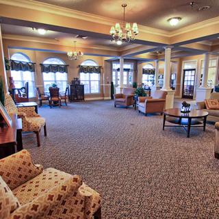A spacious lobby area featuring comfortable seating, decorative lighting, and large windows.