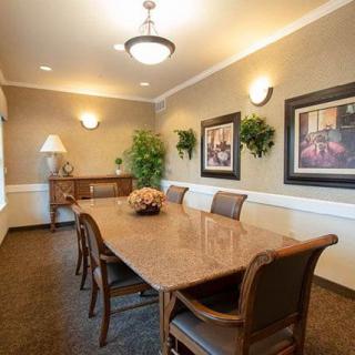 Elegant dining room with a polished wooden table and artwork on the walls.