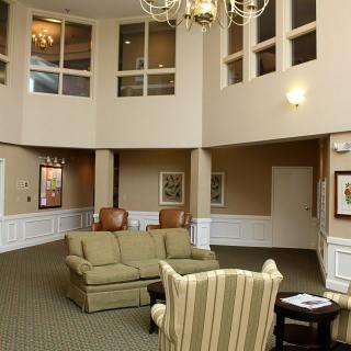 A spacious lobby with comfortable seating and a chandelier.
