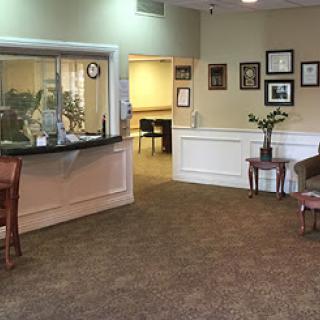 A cozy reception area featuring a welcoming atmosphere with comfortable seating and decorative elements.