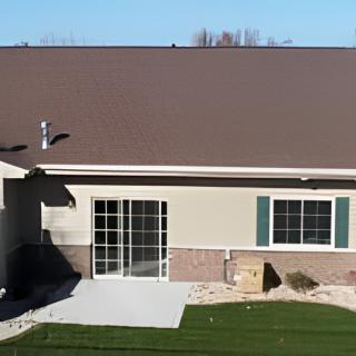 A suburban house with a small patio and a neatly trimmed lawn.