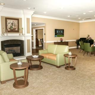 A cozy living room with comfortable seating, a fireplace, and a piano.