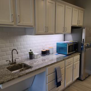 A modern kitchen with white cabinets and a sleek countertop.