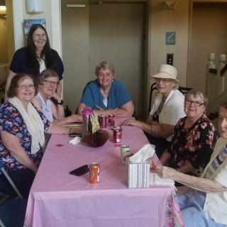 A group of people sitting around a table indoors, enjoying a gathering.
