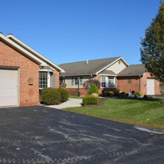 A picturesque view of a residential neighborhood showcasing brick houses with manicured lawns.