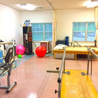 A well-equipped rehabilitation room featuring exercise equipment and therapy tools.
