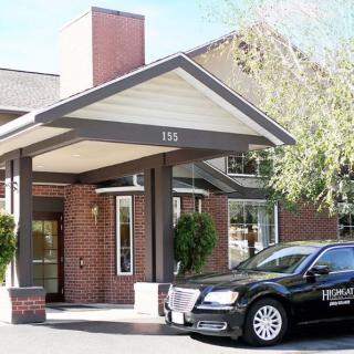 The entrance of a hotel with a car parked in front.
