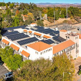 An aerial view of a building with solar panels installed on the rooftop, showcasing sustainable energy efforts.