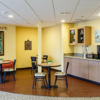 A cozy cafe interior with tables, chairs, and a coffee station.