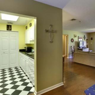 A cozy kitchen interior with a checkered floor and warm-toned walls.