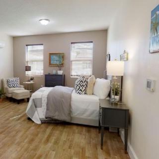 A cozy bedroom with contemporary decor, featuring a neatly made bed and stylish furnishings.