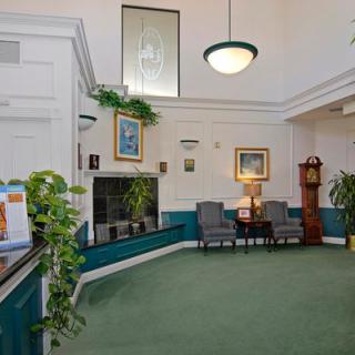 A cozy lobby area with chairs, plants, and decorative artwork.