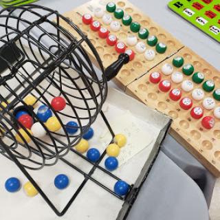 A lively setup for a fun game of bingo, featuring a rotating cage and colorful balls.