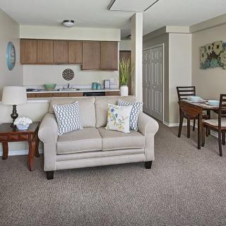 A cozy living room with a sofa, adjacent to an open kitchen and dining area.