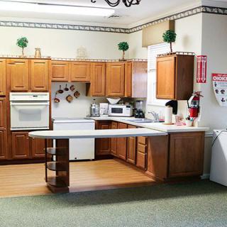 A cozy kitchen with wooden cabinets and a central countertop.
