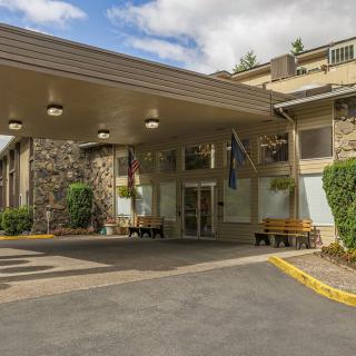 The entrance of a hotel with an awning and driveway.