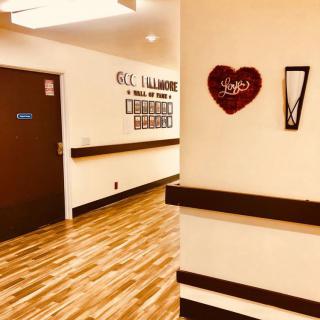 A hospital hallway with wooden flooring and heart-shaped wall decor.