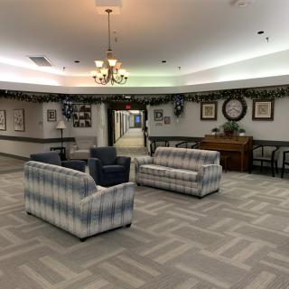 A cozy lobby seating area with couches and armchairs under a chandelier.