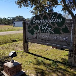 A sign for Evangeline Oaks, set in a peaceful outdoor landscape.