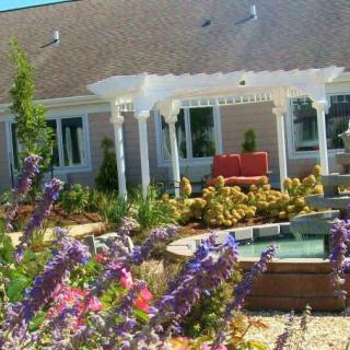 A beautiful garden with a pergola and vibrant flowers.