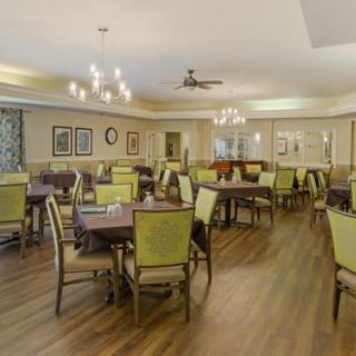 A modern dining room with green chairs and wooden floors.