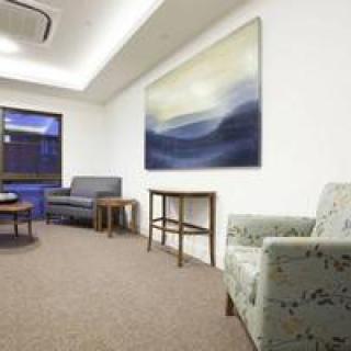A cozy waiting room with comfortable seating and calming artwork on the wall.