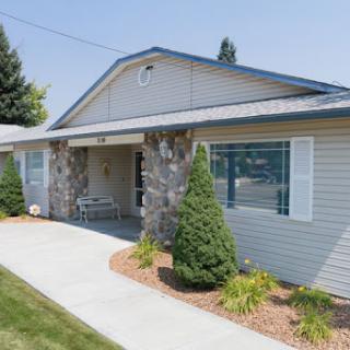 A charming single-story house featuring stone accents and well-maintained landscaping.