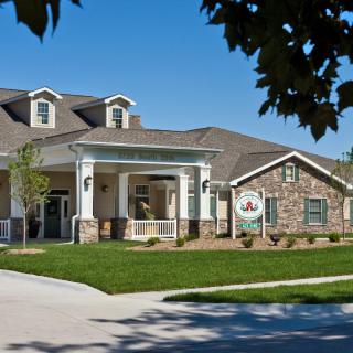 A suburban residential building with a well-maintained lawn and driveway.