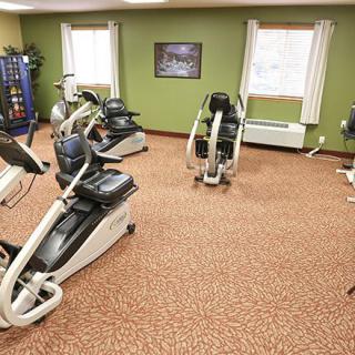 A fitness room featuring various cardio exercise machines.