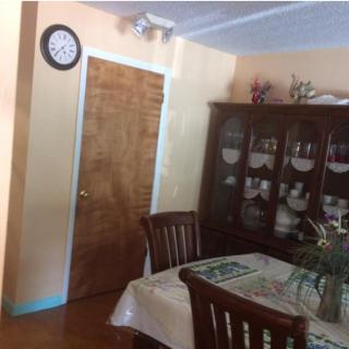 A cozy dining room with a wooden table, chairs, and a cabinet filled with dishes.