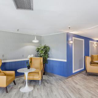 A cozy lounge area featuring modern furniture and vibrant blue walls.