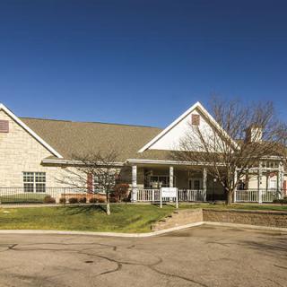 A suburban residential building with a light-colored exterior under a clear blue sky.