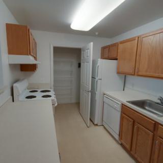 A small kitchen with wooden cabinets and basic appliances.