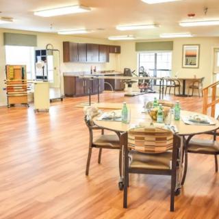 A bright and spacious dining area with a modern kitchen in the background.